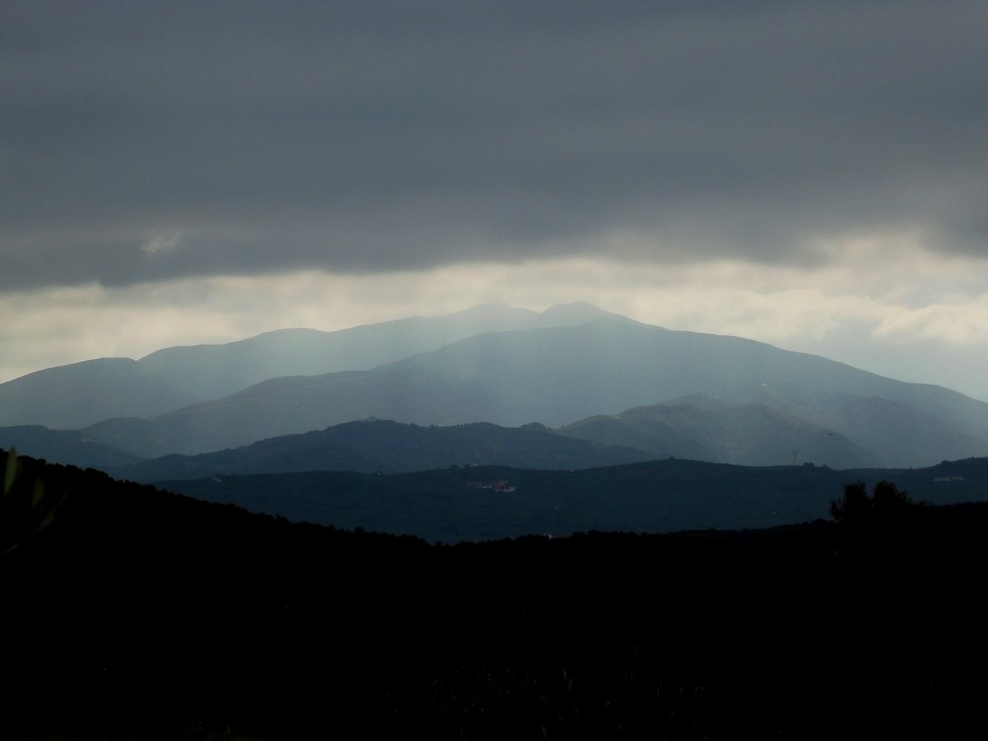 Entfernte Bergketten erstrecken sich bis zu einem nebligen Horizont.