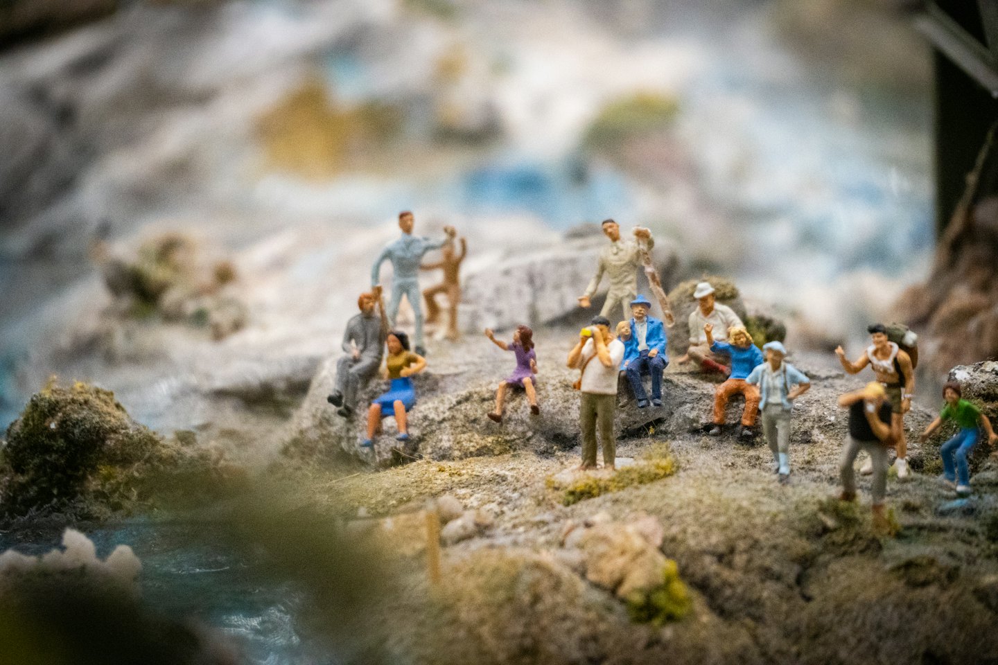 Miniaturfiguren erkunden eine strukturierte, moosbewachsene Felslandschaft.